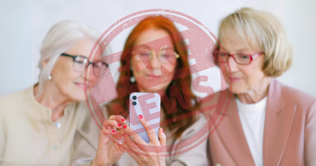 Drei Seniorinnen blicken auf ein Smartphone. Über dem Bild ist ein Aufdruck mit den Worten Fake News.
