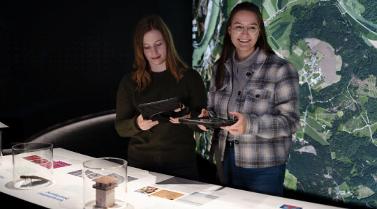 zwei junge Frauen hinter Ausstellungstisch